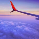 Book your Flight to Berlin now and embark on an unforgettable adventure in the vibrant capital of Germany. Don't miss out! - person in a plane flying at high altitude taking photo of left airplane wing during daytime