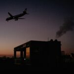airplane flying over concrete building